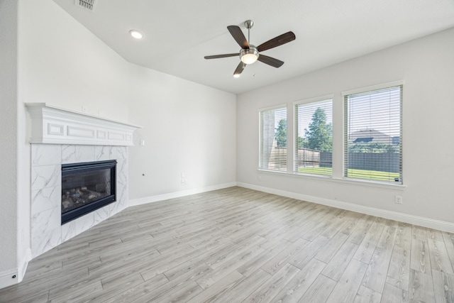 808 N Brenham Ave, Celina, TX 75009 - unfurnished living room with light wood-style flooring, a high end fireplace, ceiling fan, and baseboards