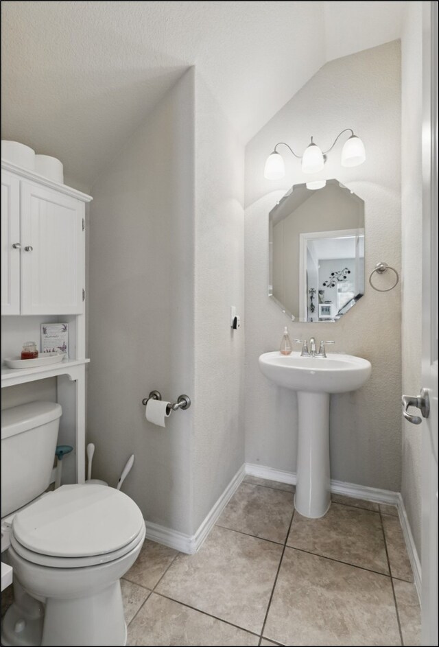 31 Oakridge Ln, Edgecliff Village, TX 76134 - half bath with vaulted ceiling, toilet, tile patterned flooring, and a sink