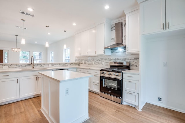 2723 Bentley Ave, Dallas, TX 75211 - kitchen with stainless steel gas range, wall chimney range hood, a sink, decorative backsplash, and light countertops