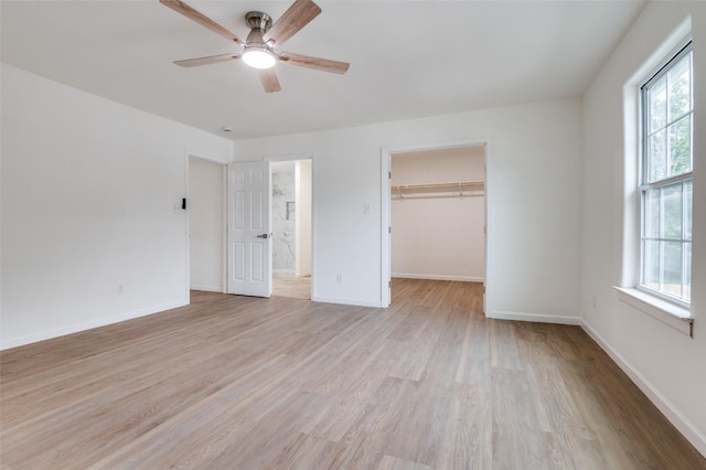 2723 Bentley Ave, Dallas, TX 75211 - unfurnished bedroom featuring light wood-style flooring, baseboards, and a spacious closet