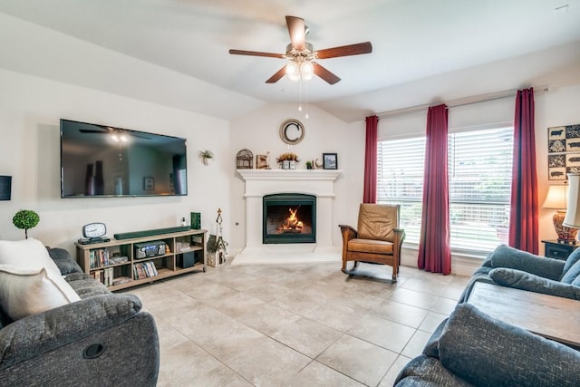 324 Jefferson Ln, Fate, TX 75189 - living room with a ceiling fan, vaulted ceiling, light tile patterned flooring, and a warm lit fireplace