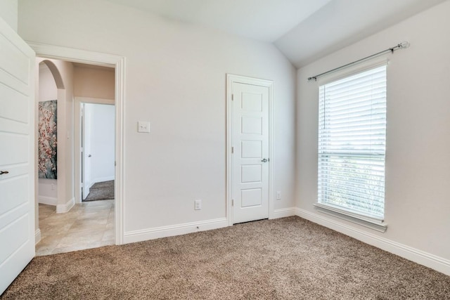 324 Jefferson Ln, Fate, TX 75189 - unfurnished bedroom with light carpet, lofted ceiling, arched walkways, and baseboards