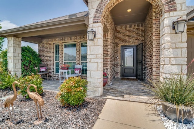 324 Jefferson Ln, Fate, TX 75189 - property entrance with brick siding, covered porch, and stone siding