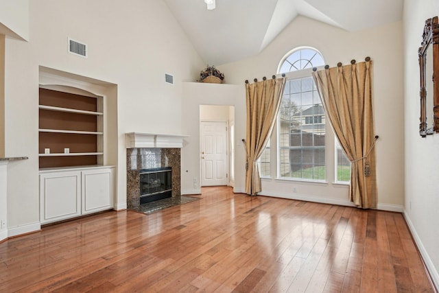 604 Nelson Ct, Plano, TX 75025 - unfurnished living room featuring healthy amount of natural light, hardwood / wood-style floors, built in features, a fireplace, and high vaulted ceiling