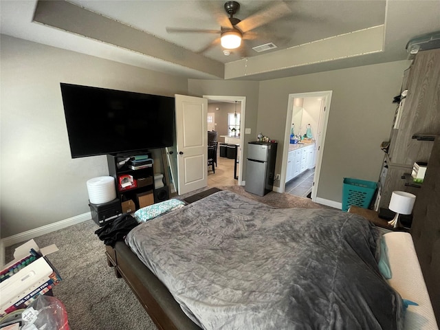 108 Ronnie Ln, Weatherford, TX 76088 - carpeted bedroom featuring freestanding refrigerator, baseboards, ensuite bathroom, and a raised ceiling