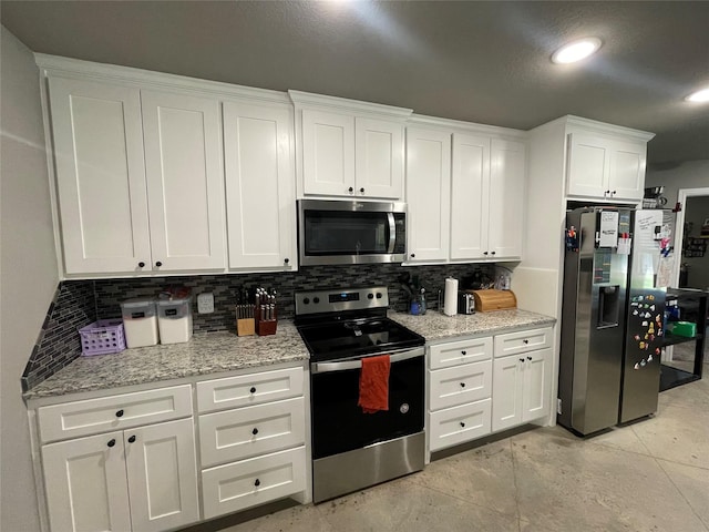 108 Ronnie Ln, Weatherford, TX 76088 - kitchen featuring stainless steel appliances, white cabinetry, decorative backsplash, light stone countertops, and concrete flooring