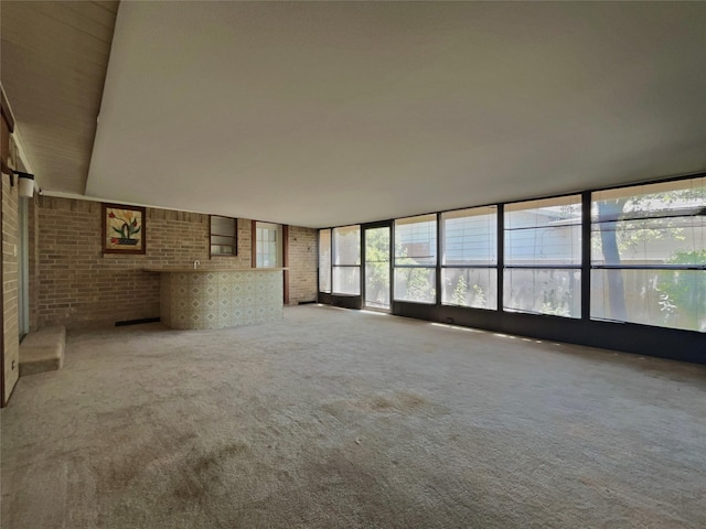 3614 Matador Dr, Garland, TX 75042 - unfurnished living room with brick wall and carpet flooring