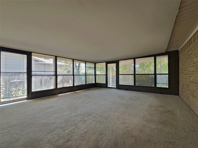 3614 Matador Dr, Garland, TX 75042 - unfurnished sunroom featuring brick wall and carpet floors