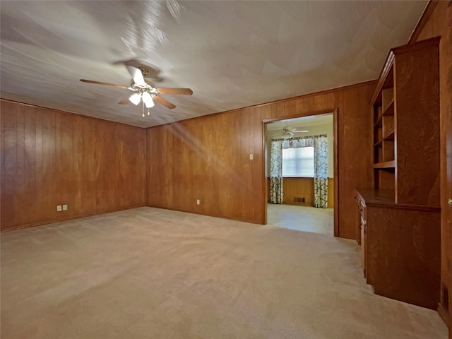3614 Matador Dr, Garland, TX 75042 - empty room featuring ceiling fan, wood walls, and light colored carpet