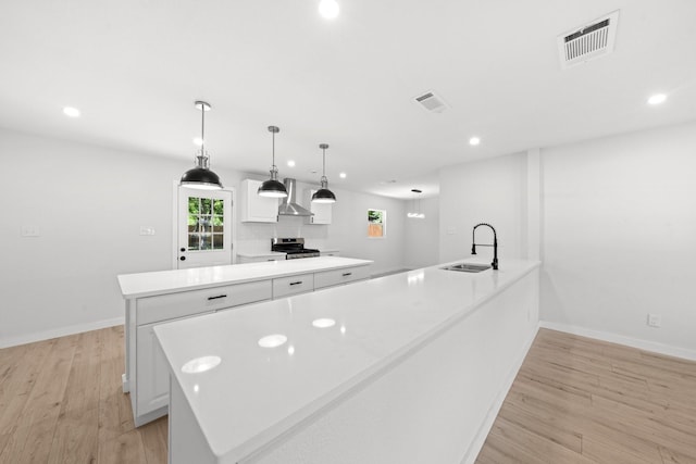 4618 Black Rock Dr, Dallas, TX 75211 - kitchen with a sink, stainless steel stove, recessed lighting, a center island, and white cabinets