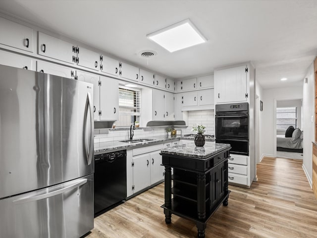 110 N Willow St, Mansfield, TX 76063 - kitchen featuring black appliances, a sink, a warming drawer, and white cabinets