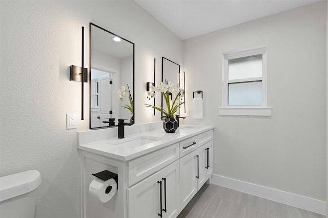 5009 Stacey Ave, Fort Worth, TX 76132 - bathroom featuring toilet, baseboards, and double vanity