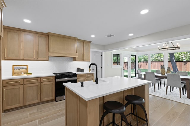 5009 Stacey Ave, Fort Worth, TX 76132 - kitchen featuring gas stove, a sink, a chandelier, light countertops, and a kitchen breakfast bar