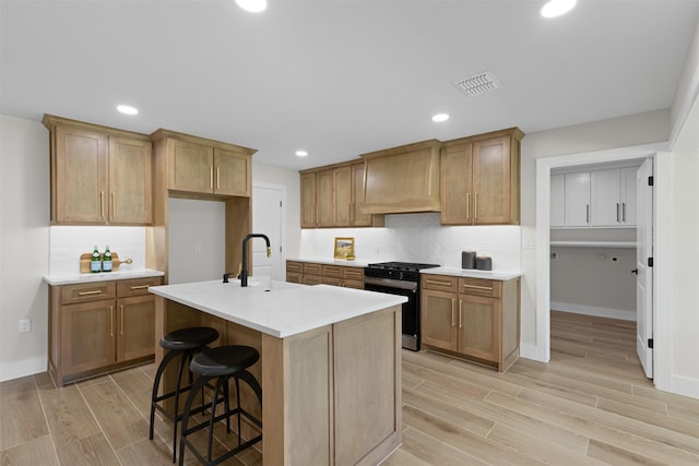 5009 Stacey Ave, Fort Worth, TX 76132 - kitchen with range with gas cooktop, a sink, premium range hood, light wood-style floors, and light countertops