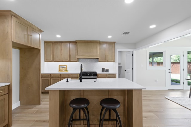5009 Stacey Ave, Fort Worth, TX 76132 - kitchen featuring custom range hood, a breakfast bar area, baseboards, recessed lighting, and light countertops
