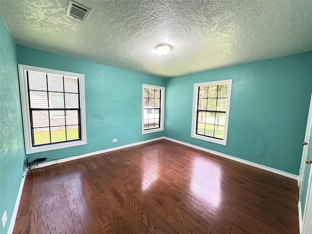1205 Lamar, Mount Pleasant, TX 75455 - empty room with wood finished floors, a textured ceiling, and baseboards