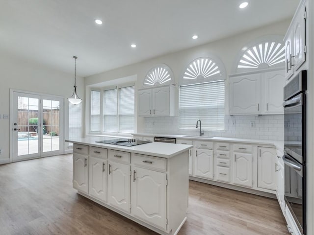 1428 Charlotte Way, Carrollton, TX 75007 - kitchen featuring appliances with stainless steel finishes, a kitchen island, white cabinetry, backsplash, and recessed lighting