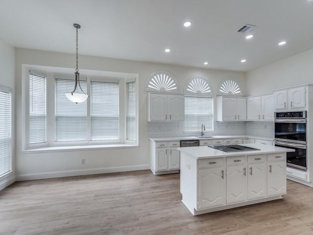 1428 Charlotte Way, Carrollton, TX 75007 - kitchen featuring stainless steel appliances, white cabinetry, a center island, light countertops, and recessed lighting