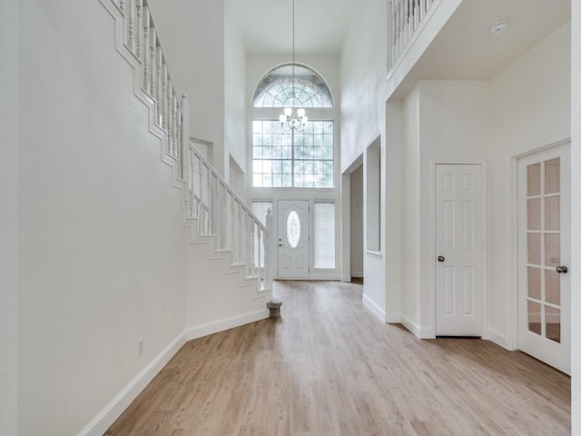 1428 Charlotte Way, Carrollton, TX 75007 - entrance foyer featuring a high ceiling, stairway, a chandelier, light wood-type flooring, and baseboards
