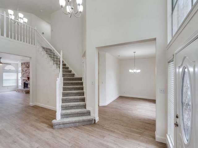 1428 Charlotte Way, Carrollton, TX 75007 - entrance foyer featuring a chandelier, a high ceiling, wood finished floors, stairway, and a fireplace