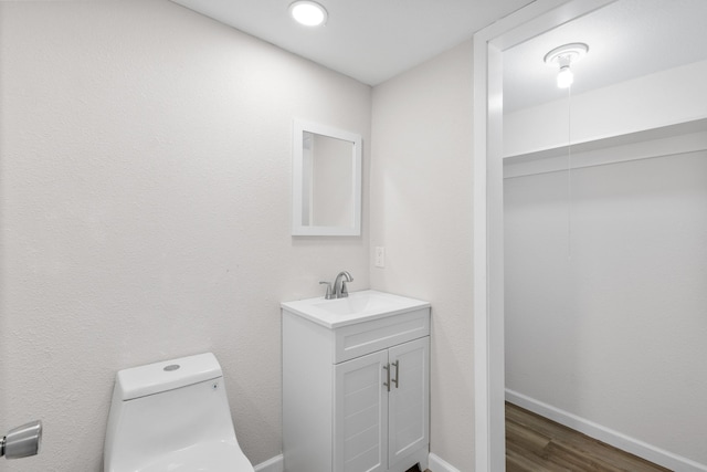 903 1st St, Bridgeport, TX 76426 - half bathroom featuring vanity, toilet, wood finished floors, and baseboards