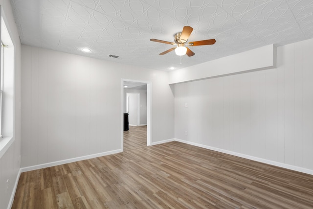 903 1st St, Bridgeport, TX 76426 - spare room with wood finished floors, a ceiling fan, baseboards, and an ornate ceiling