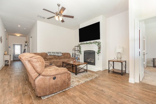 3021 Cobalt Dr, Aubrey, TX 76227 - living area with light wood finished floors, ceiling fan, a glass covered fireplace, and baseboards