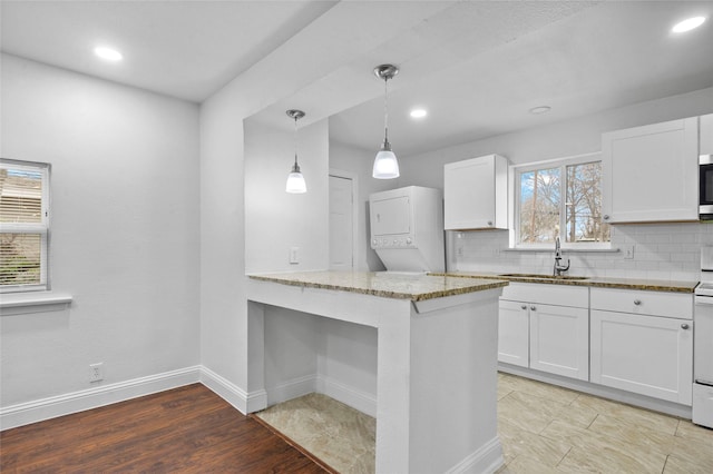 3334 Modlin St, Dallas, TX 75228 - kitchen with a sink, stacked washer / dryer, light stone counters, white cabinets, and recessed lighting