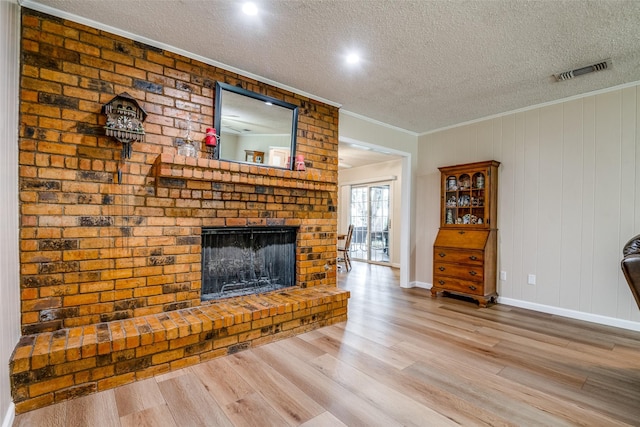 508 Fox Trl, Greenville, TX 75402 - living room with ornamental molding, a textured ceiling, wood finished floors, a fireplace, and baseboards