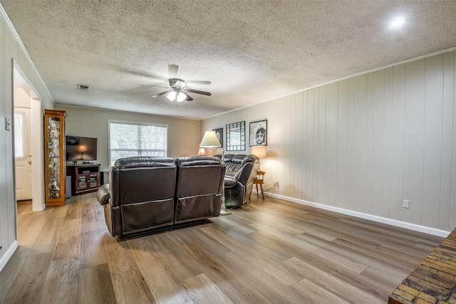 508 Fox Trl, Greenville, TX 75402 - living room featuring wood finished floors, ceiling fan, crown molding, baseboards, and a textured ceiling