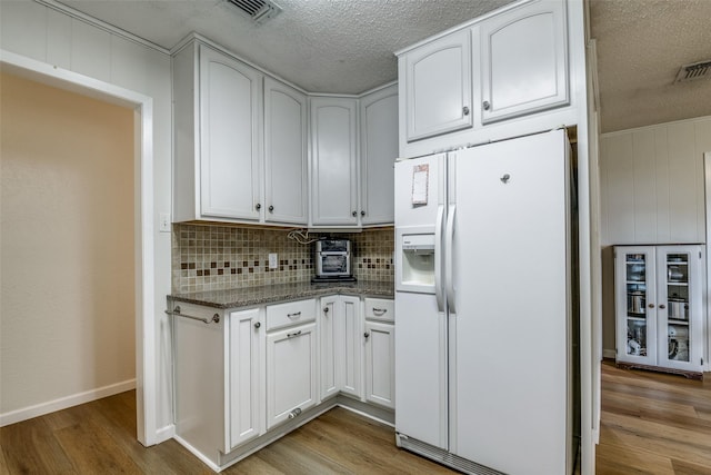508 Fox Trl, Greenville, TX 75402 - kitchen with white refrigerator with ice dispenser, a textured ceiling, backsplash, beverage cooler, and wood finished floors