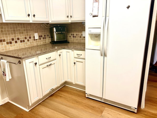 508 Fox Trl, Greenville, TX 75402 - kitchen featuring white refrigerator with ice dispenser, light wood-style flooring, tasteful backsplash, stone counters, and white cabinets