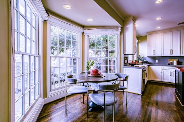 2916 Sale St, Dallas, TX 75219 - kitchen with white cabinets, dark wood finished floors, recessed lighting, dark countertops, and ornamental molding