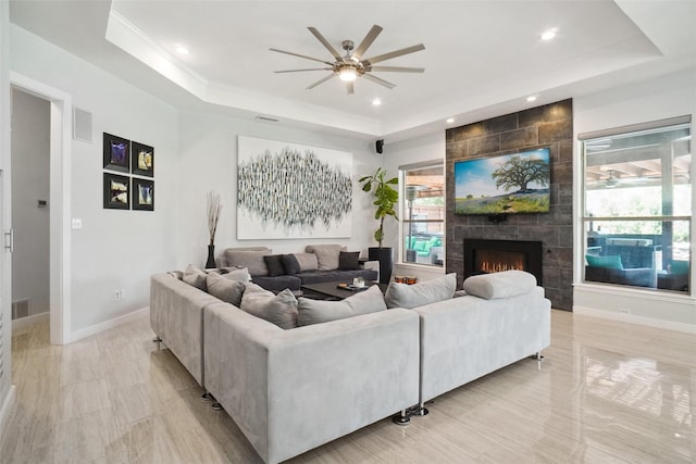 1302 Kelly Green Ct, Keller, TX 76248 - living area with a tray ceiling, a ceiling fan, a tiled fireplace, healthy amount of natural light, and recessed lighting