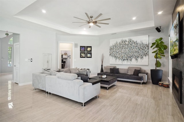1302 Kelly Green Ct, Keller, TX 76248 - living room featuring a tray ceiling, ceiling fan, a large fireplace, baseboards, and recessed lighting