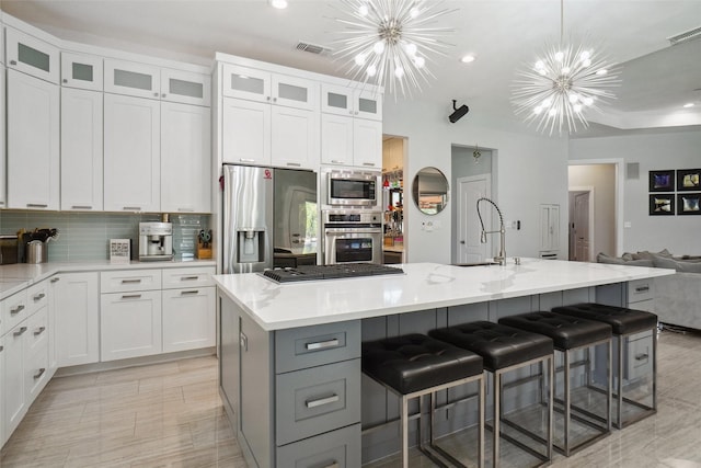1302 Kelly Green Ct, Keller, TX 76248 - kitchen featuring stainless steel appliances, a chandelier, a sink, open floor plan, and white cabinets