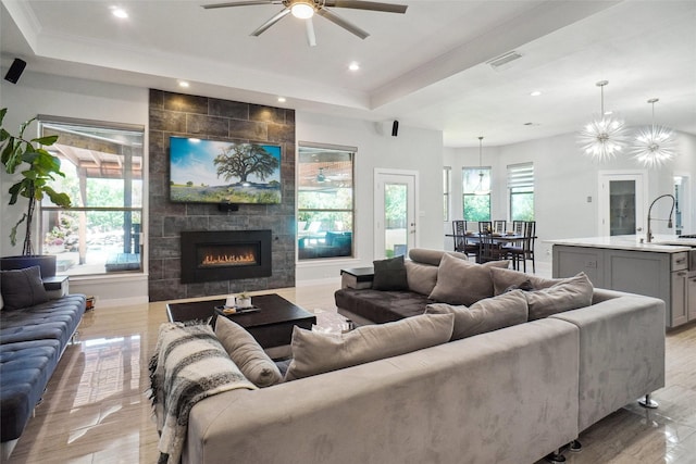 1302 Kelly Green Ct, Keller, TX 76248 - living room with a raised ceiling, ceiling fan, recessed lighting, a fireplace, and ornamental molding