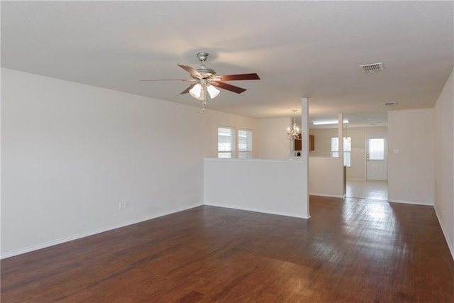 2913 Paddock Way, Denton, TX 76210 - unfurnished living room featuring a chandelier, ceiling fan, dark wood-style floors, and baseboards