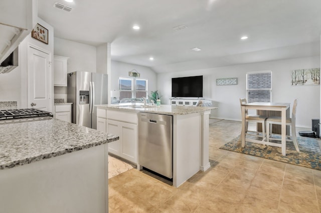 16637 Friesland Ln, Justin, TX 76247 - kitchen with stainless steel appliances, white cabinets, an island with sink, a sink, and light stone countertops