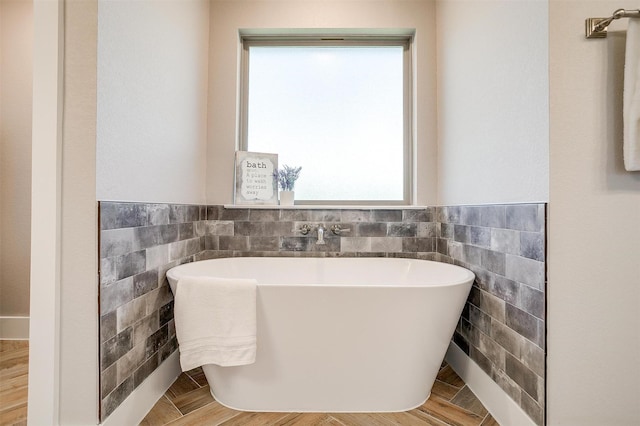 4017 Crick Ct, Weatherford, TX 76087 - full bath featuring tile walls, plenty of natural light, a freestanding tub, and wainscoting