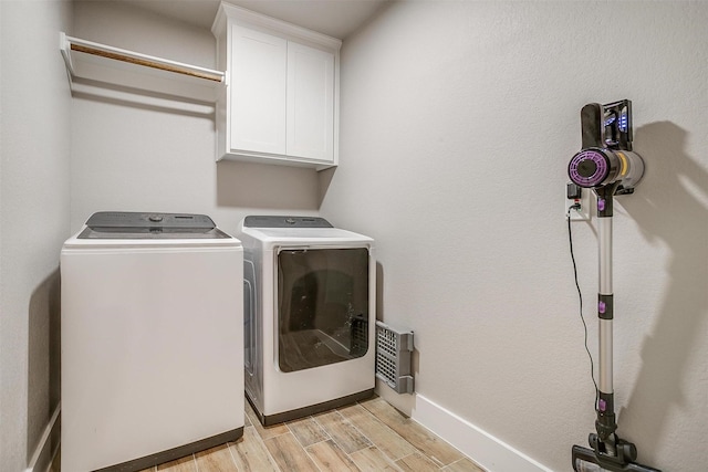 4017 Crick Ct, Weatherford, TX 76087 - laundry area with cabinet space, washer and dryer, light wood-style flooring, and baseboards
