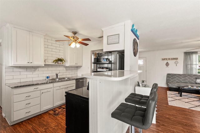 400 Causeway Vw, Seven Points, TX 75143 - kitchen featuring stainless steel dishwasher, dark wood-style flooring, a breakfast bar area, ceiling fan, and tasteful backsplash