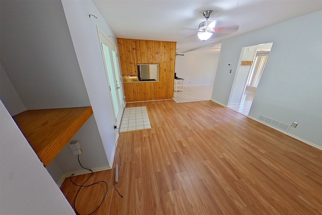 1602 England Rd, Arlington, TX 76013 - unfurnished living room with a ceiling fan, light wood-style floors, baseboards, and wooden walls
