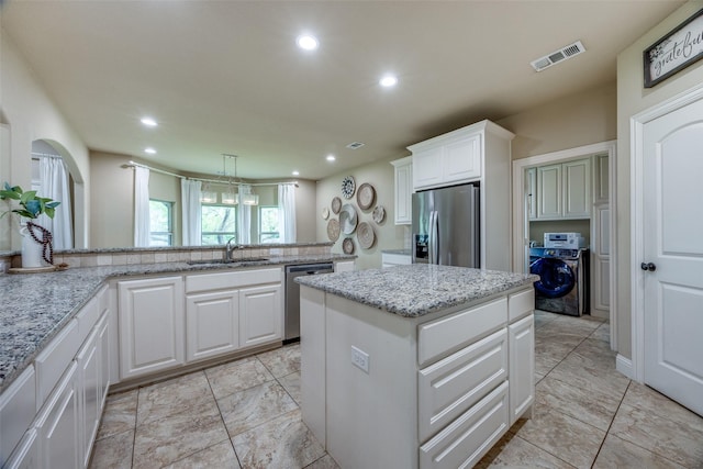 3331 Preston Club Dr, Sherman, TX 75092 - kitchen featuring appliances with stainless steel finishes, a sink, washer / clothes dryer, a center island, and recessed lighting