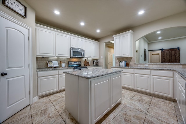 3331 Preston Club Dr, Sherman, TX 75092 - kitchen featuring appliances with stainless steel finishes, tasteful backsplash, white cabinetry, a center island, and recessed lighting