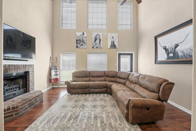 210 Sendero Dr, Waxahachie, TX 75165 - living area with wood finished floors, baseboards, a fireplace, a towering ceiling, and ceiling fan