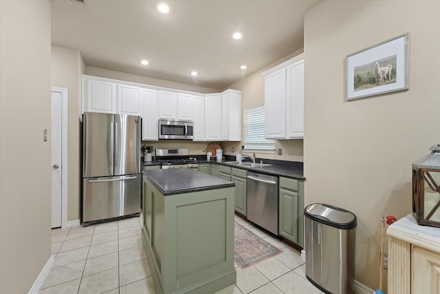 210 Sendero Dr, Waxahachie, TX 75165 - kitchen featuring stainless steel appliances, dark countertops, white cabinets, a center island, and a sink