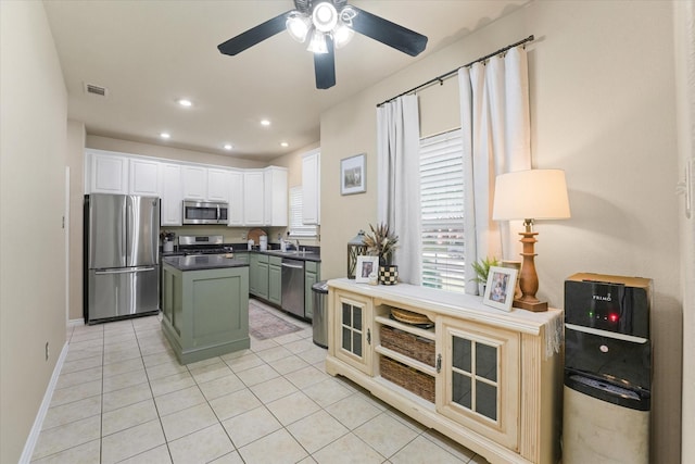 210 Sendero Dr, Waxahachie, TX 75165 - kitchen featuring appliances with stainless steel finishes, dark countertops, white cabinets, light tile patterned flooring, and a ceiling fan