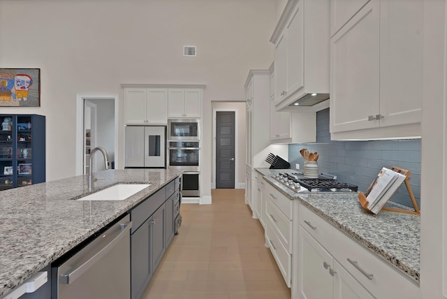 1306 Blue Lake Blvd, Arlington, TX 76005 - kitchen featuring a sink, stainless steel appliances, white cabinetry, and tasteful backsplash