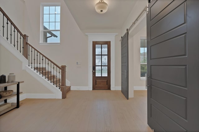 1306 Blue Lake Blvd, Arlington, TX 76005 - entryway featuring a barn door, stairway, baseboards, and light wood finished floors